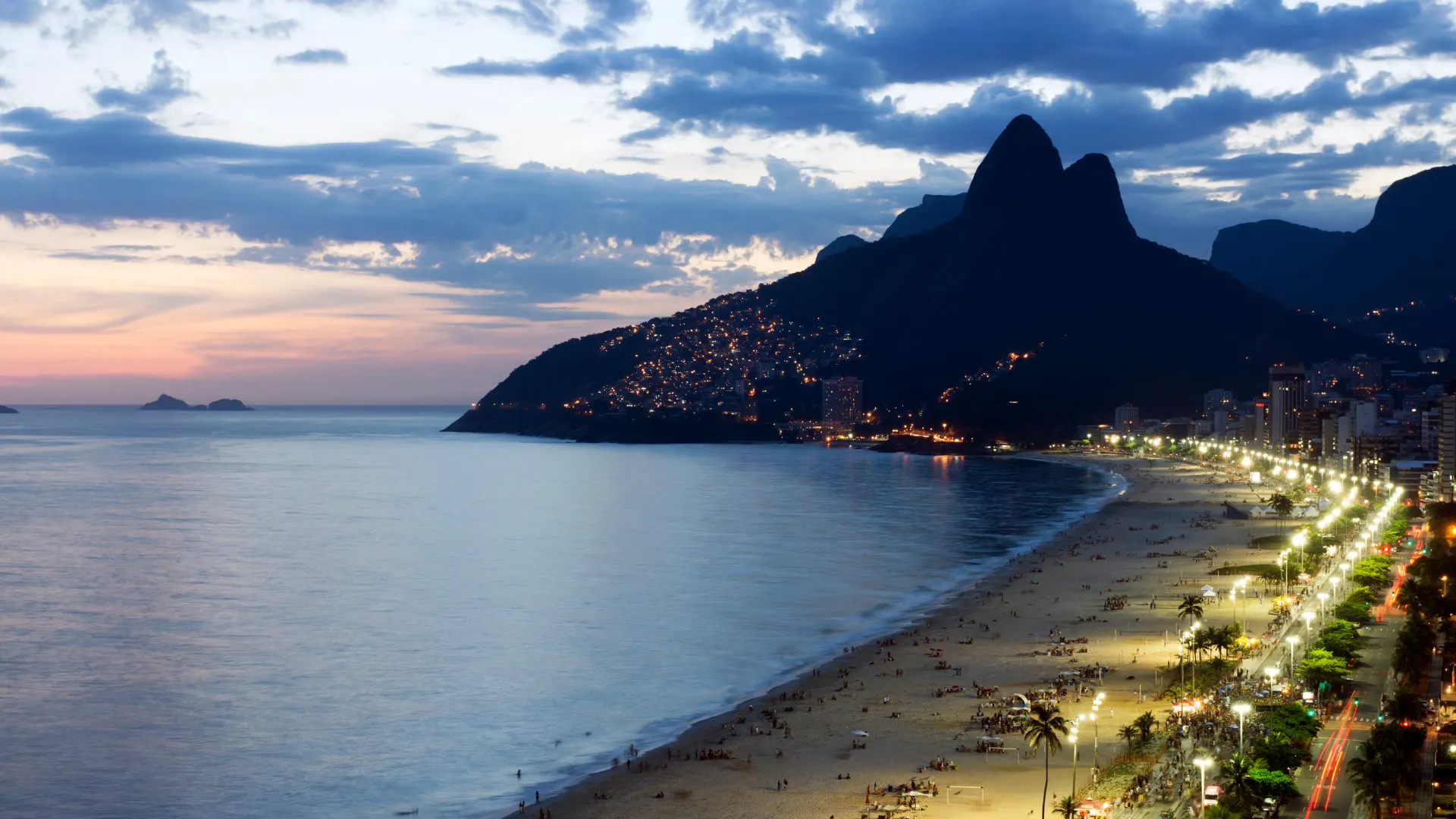 Vista noturna da orla do Leblon com o Morro Dois Irmãos ao fundo